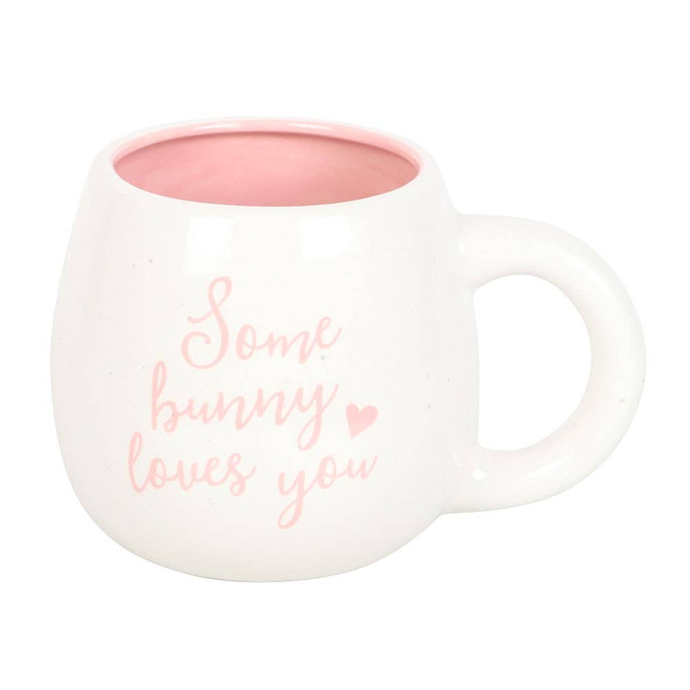 White mug with pink interior and 'Some bunny loves you' text on a white background