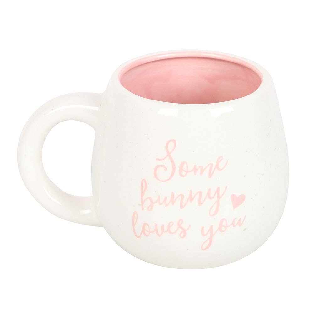 White mug with pink interior and 'Some bunny loves you' text on a white background