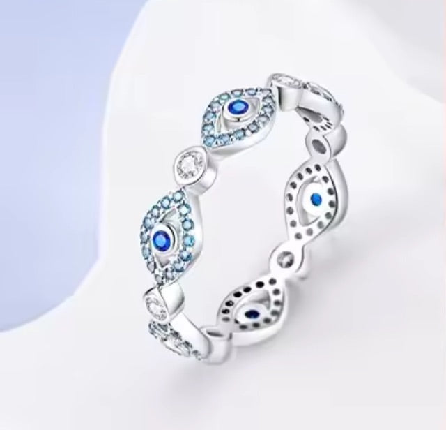 Silver ring with blue gemstones on a light background